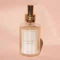 Perfume bottle labeled 'Coconut Cloud' by 'North+Rose' on a pink background