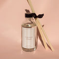 Reed diffuser with 'Coconut Cloud' label on a pink background
