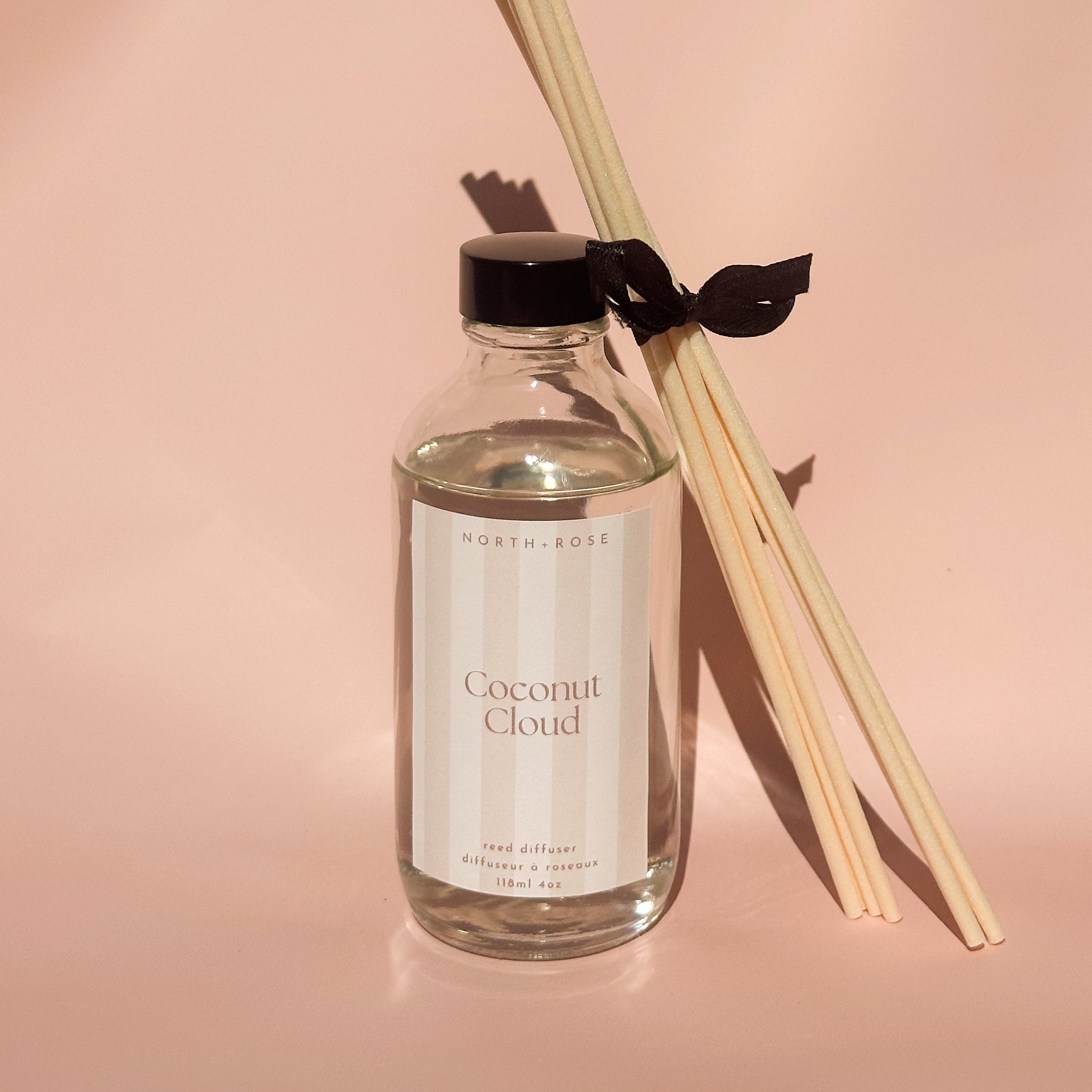Reed diffuser with 'Coconut Cloud' label on a pink background